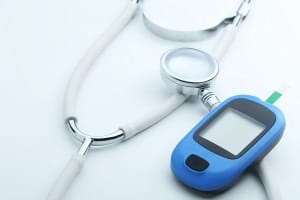 Blood glucose meter and stethoscope on white background