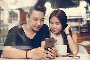 Couple using a phone at a cafe
